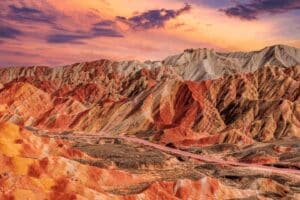 Vibrant layered rock formations of Zhangye Danxia National Geopark at sunset in Gansu, China.