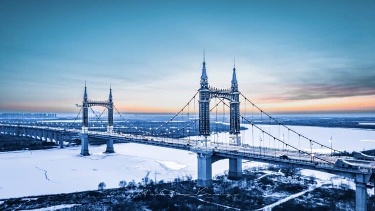 Aerial view of Yangmingtan Bridge over the frozen Songhua River at sunset in Harbin, China.